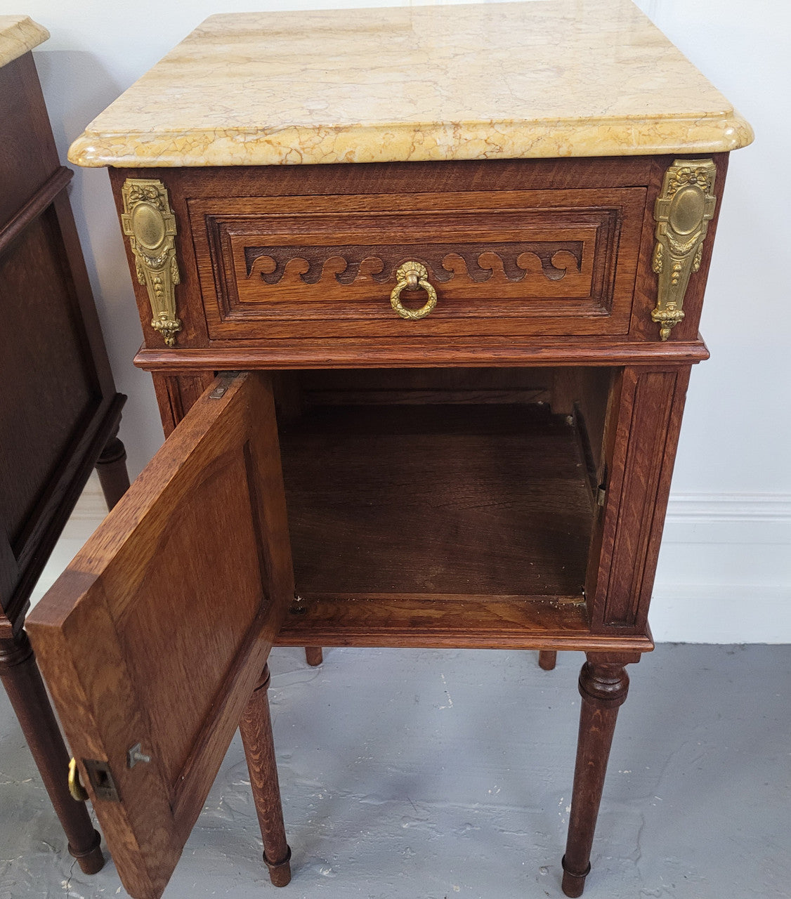 French Oak pair of Louis 16th style marble top bedsides with stunning bronze mounts. They have been sourced from France and are in good original detailed condition.