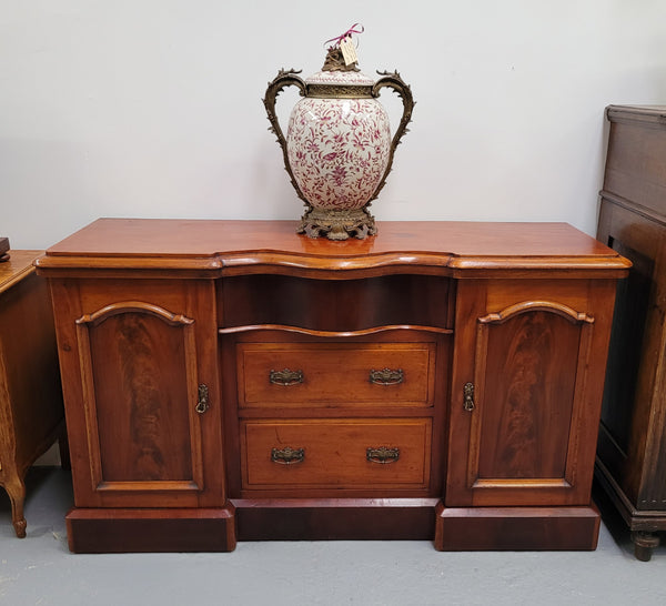 An English Victorian Mahogany sideboard with nine drawers. This amazing piece has loads of storage with three central drawers in the middle and a further six drawers. It has three each side located behind two doors. It has been sourced from locally and in original detailed condition.