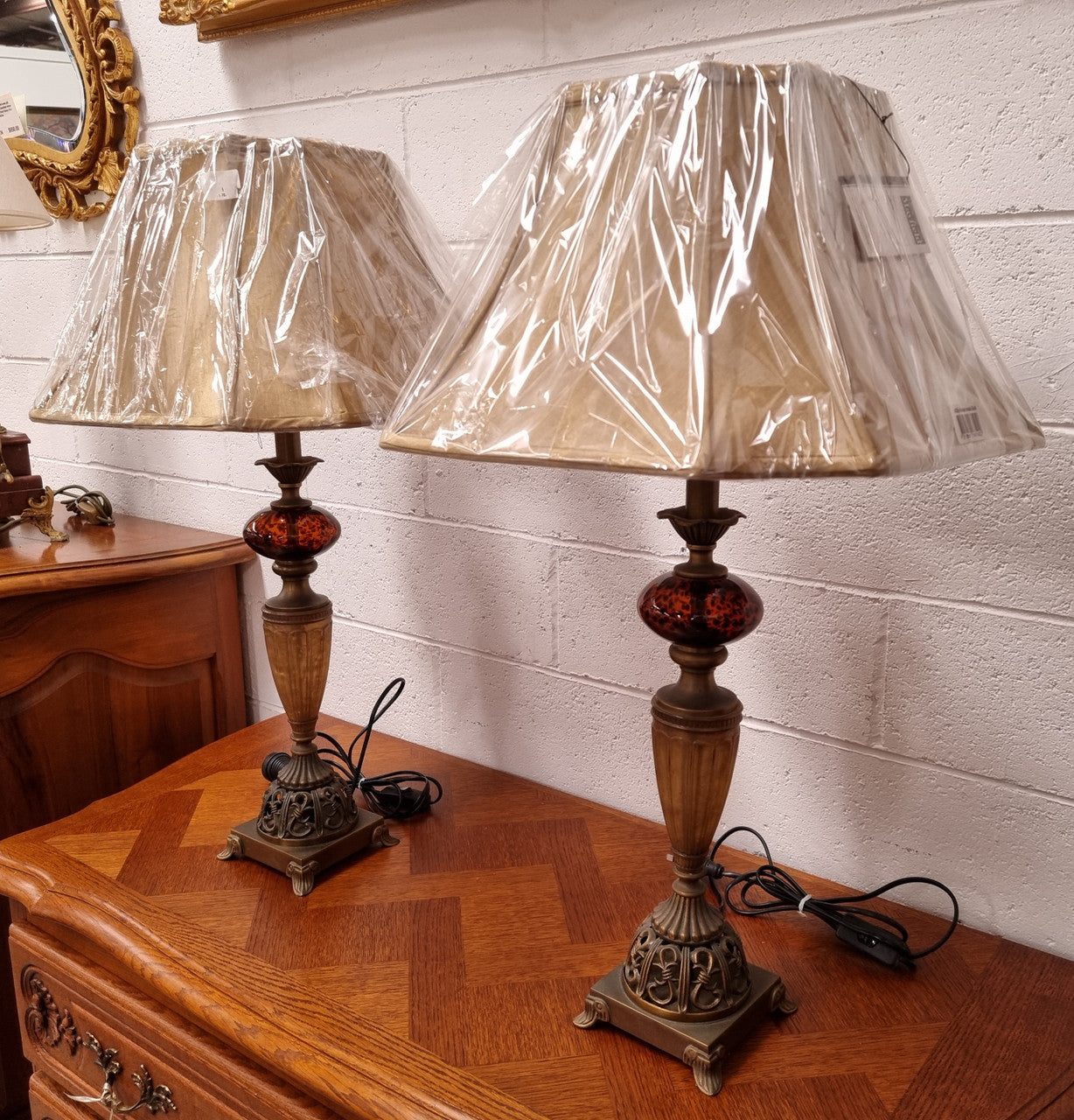 Beautiful pair of metal and glass lamp bases with new gold shades. They are in good original working condition and have been sourced locally.