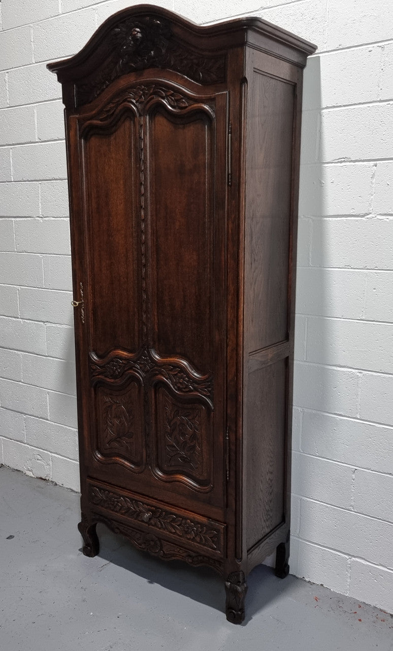 An Attractive French Louis XV style single-door ‘Marriage Armoire’. Beautifully arched crest with detailed carved flowers along with an arched single door which repeats the floral carvings. It is also has plenty of storage space with three adjustable shelves along with a drawer at the bottom. All in good original detailed condition.