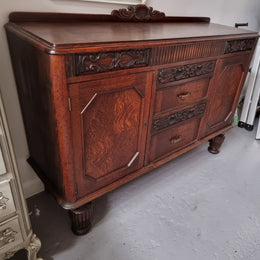 Art Deco Tudor style Oak sideboard with decorative carved detail. Plenty of storage space with two cupboards and four drawers. It has been sourced locally and is in good original detailed condition.