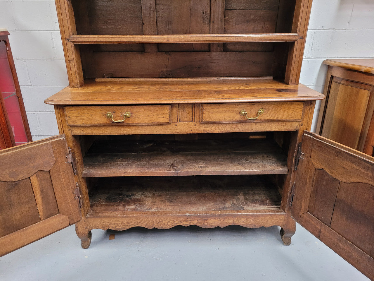 Charming 18th Century French Oak Vaisselier / kitchen dresser with two cupboard doors and three open shelves at the top. Sourced from France and in good original detailed condition.