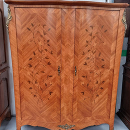Charming French Louis XV Style Marquetry Inlaid Two Door Armoire. Features three adjustable shelves and ormolu trim. It has been sourced from France and is in good original condition.
