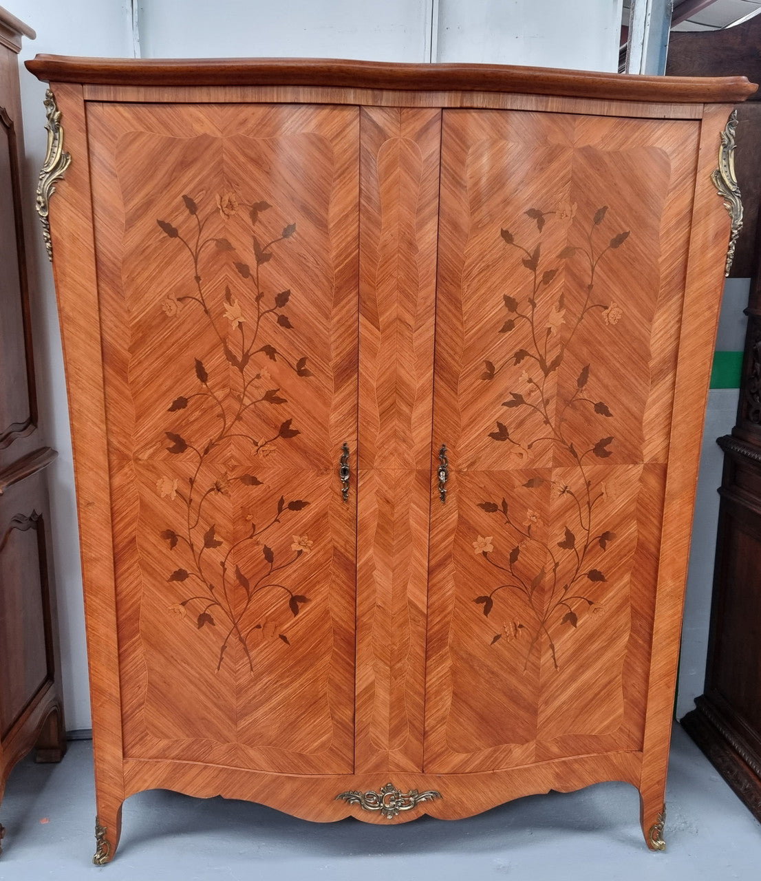 Charming French Louis XV Style Marquetry Inlaid Two Door Armoire. Features three adjustable shelves and ormolu trim. It has been sourced from France and is in good original condition.