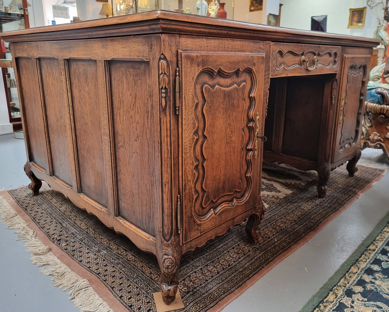 Fabulous Louis XV style French Oak beautifully carved full partners desk. Both sides have a functioning drawer in the middle and two cupboards either side. On both sides one cupboard door opens up to four smaller internal drawers. Plenty of storage space and a large top surface to work on. It is in good original detailed condition.