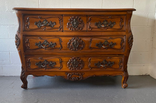 French Walnut Louis XV style five drawer commode. It has a beautiful wooden top and is beautifully carved. It is in good original detailed condition.