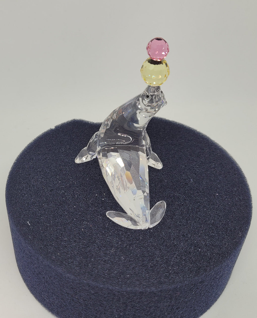 Swarovski crystal juggling seal. Jet eyes and balancing pink & yellow balls. Introduced 2003 and retired 2007.  Comes with original box.