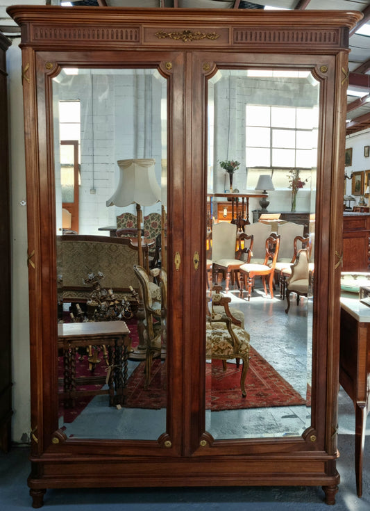 French Louis XVI style mirrored two door armoire/wardrobe. It has plenty of hanging space as well as two drawers at the bottom. In good original detailed condition.