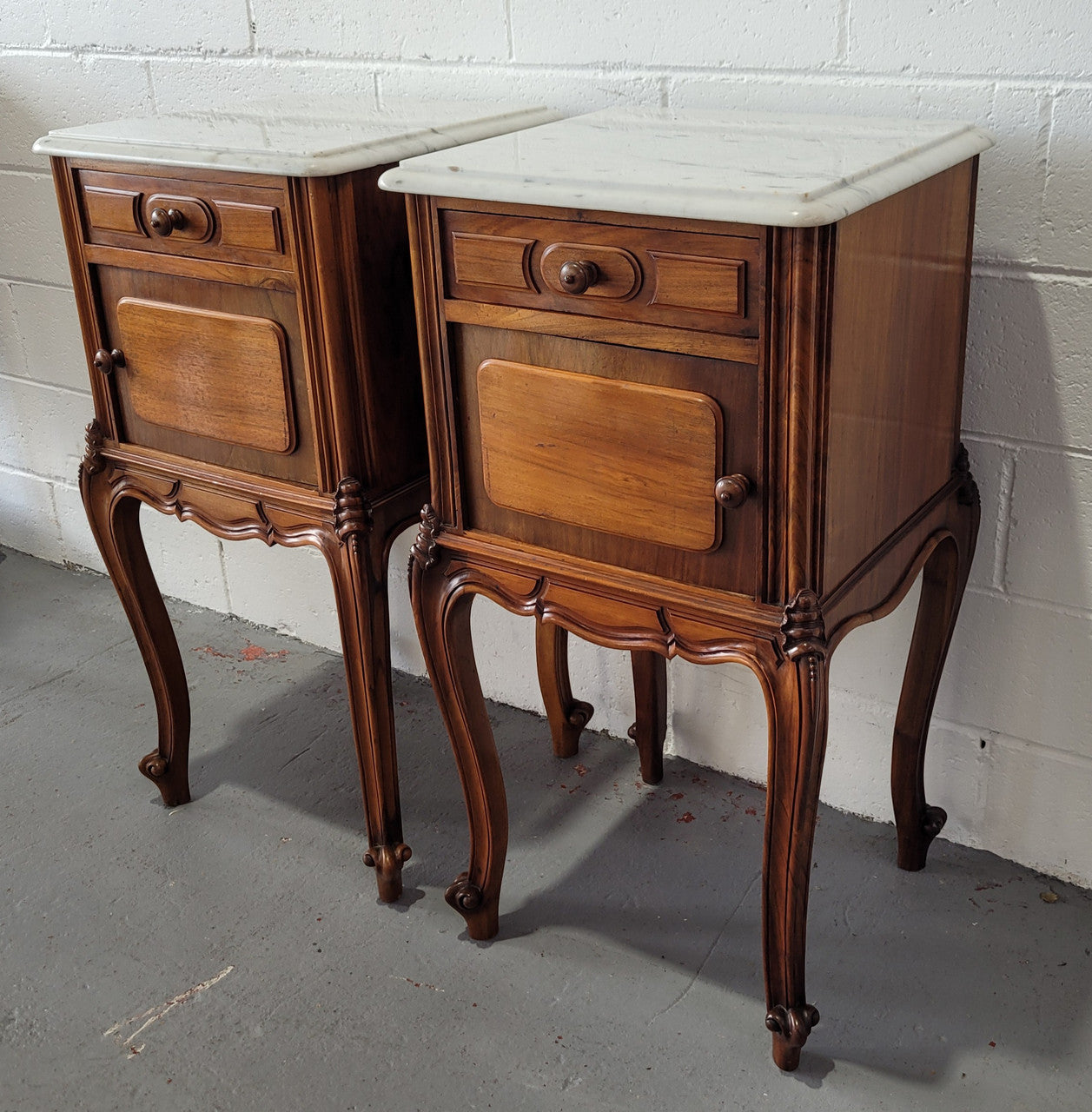 Pair of stunning Louis XV style French Walnut white marble top bedside cabinets. They have one drawer and a cupboard that is marble lined. The marble has been polished and they are in good original detailed condition.