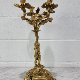 A pretty 19th Century French gilt bronze candelabra featuring a cherub. In good condition. Circa 1880.