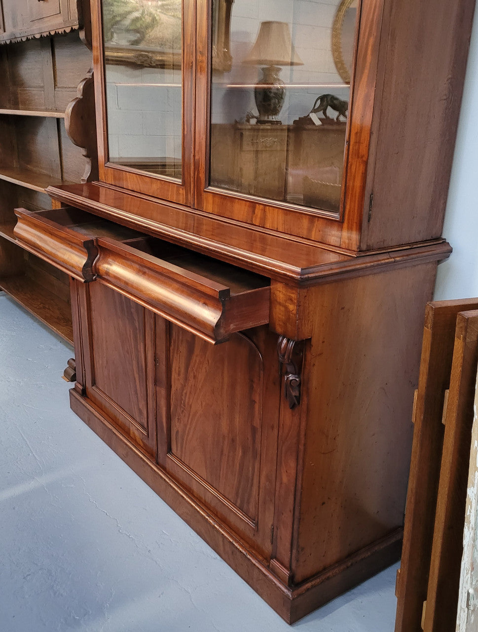 Early Victorian large flame Mahogany bookcase. Plenty of storage room with two doors and two drawers. In very good original detailed condition.