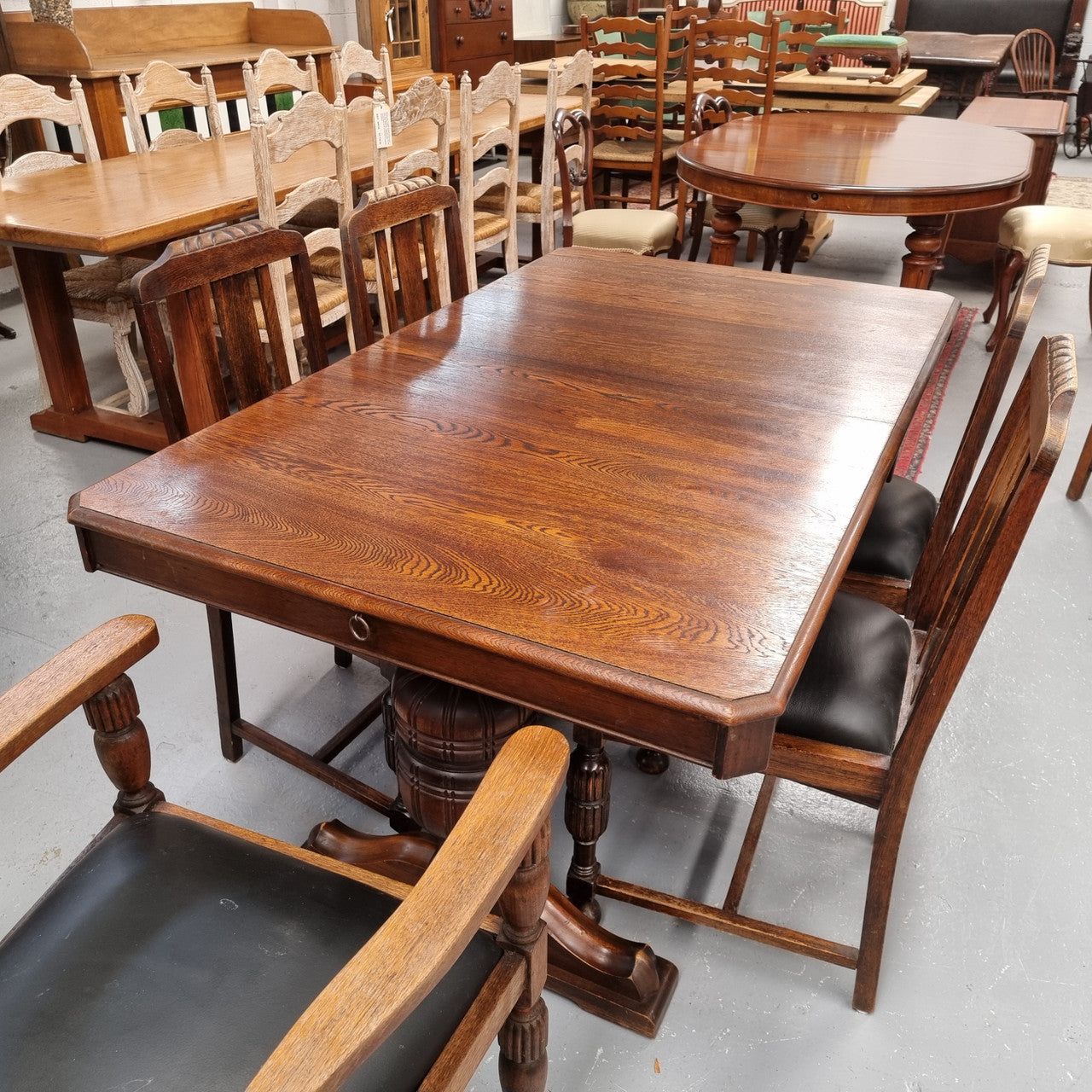 Tudor oak dining setting consisting of draw leaf extension table, 4 dining chairs and 2 carver chairs. Upholstery in excellent condition. Circa: 1930’s. The table, chair and carver chairs are in good original detailed condition.