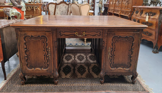 Fabulous Louis XV style French Oak beautifully carved full partners desk. Both sides have a functioning drawer in the middle and two cupboards either side. On both sides one cupboard door opens up to four smaller internal drawers. Plenty of storage space and a large top surface to work on. It is in good original detailed condition.