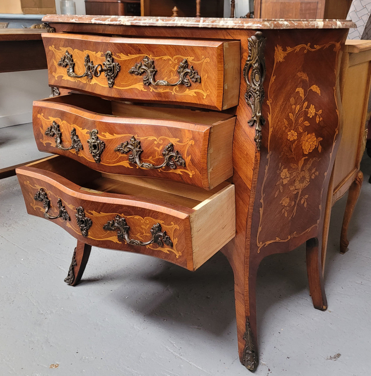Antique French Louis XV style compact three drawer marble top commode with marquetry inlay and ormolu mounts. Sourced from France and in good original detailed condition.