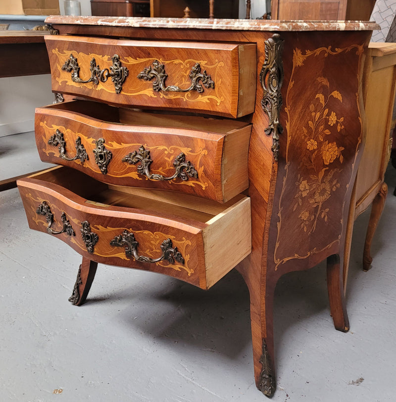 Antique French Louis XV style compact three drawer marble top commode with marquetry inlay and ormolu mounts. Sourced from France and in good original detailed condition.
