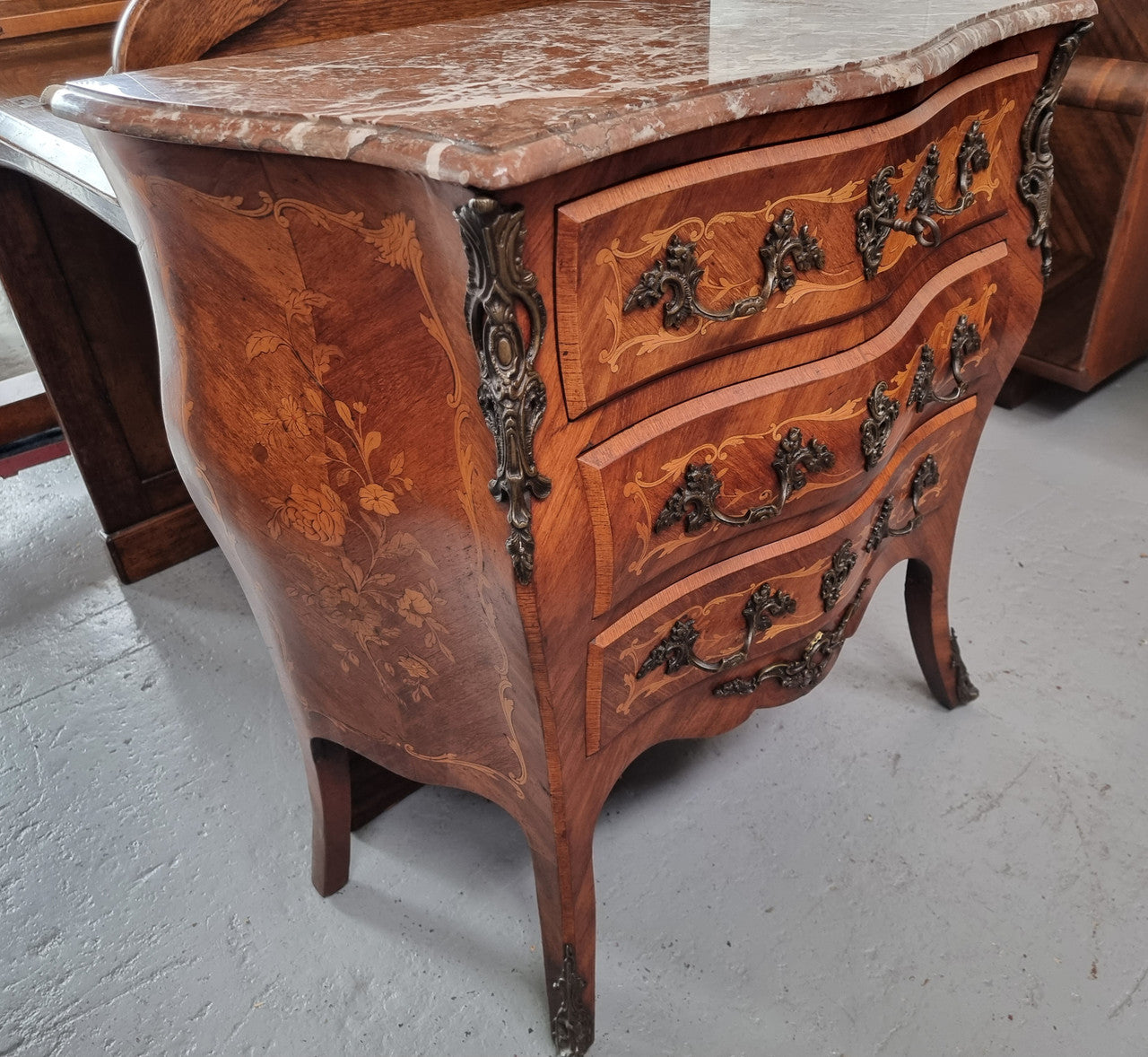 Antique French Louis XV style compact three drawer marble top commode with marquetry inlay and ormolu mounts. Sourced from France and in good original detailed condition.