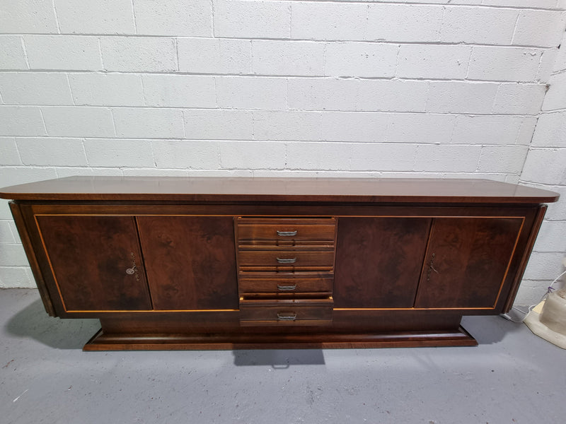 Amazing French Walnut Art deco four door buffet. The doors either side open to a fixed shelf and plenty of added storage with four drawers. In good original detailed condition.