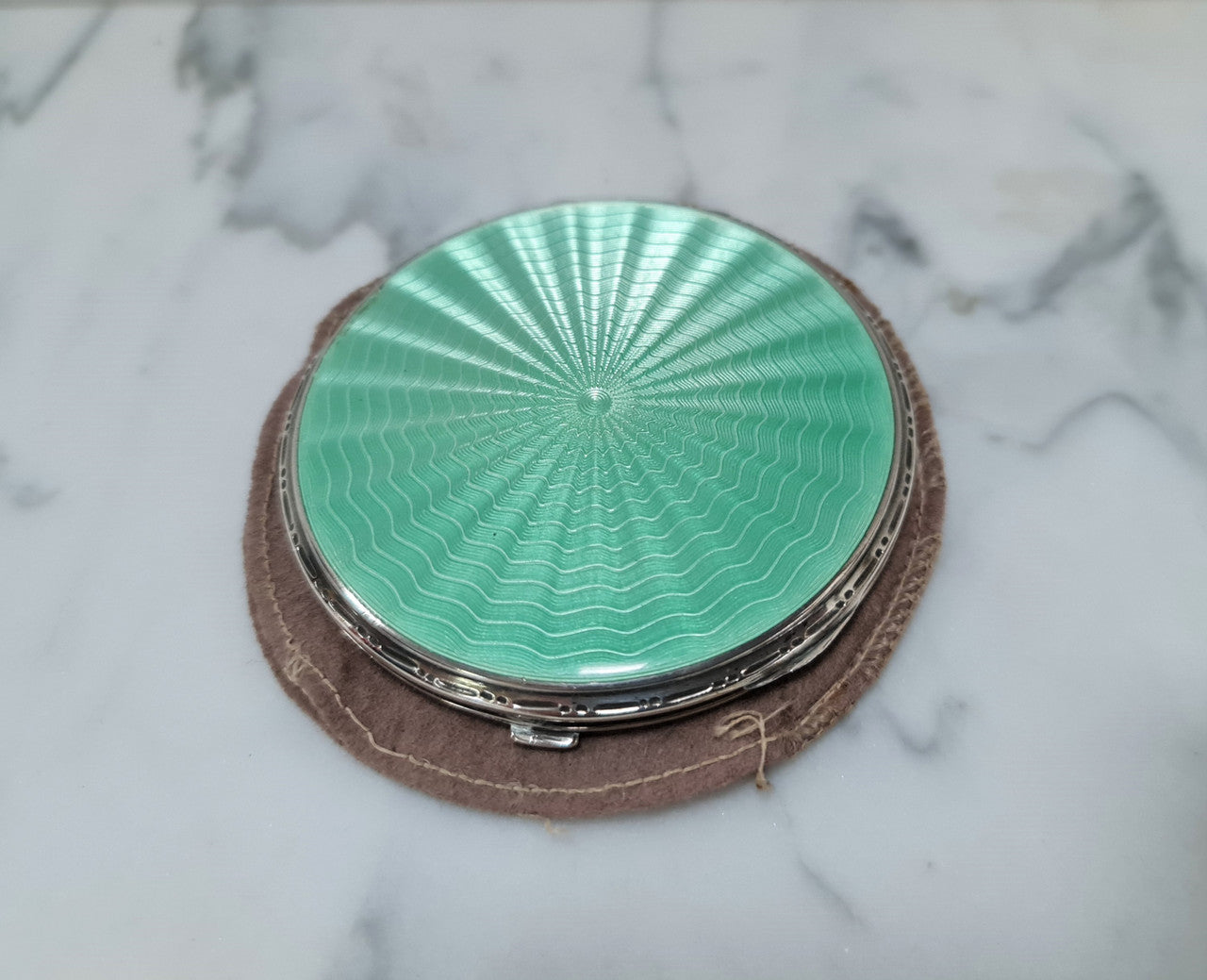 This beautiful sterling silver compact with interior mirror has a stunning mint green guilloche top in very good condition . It is marked "Birmingham 1937".