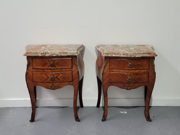 Pair of Louis XV commode style two drawer bedsides with beautiful marble tops and decorative mounts. They are a rare size and are in good, detailed condition.