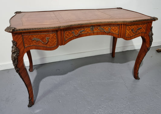 An impressive French kingwood and ormolu mounted bureau plat. It has a brown tooled leather writing surface, three decorated frieze drawers to the shaped apron with foliate swing handles and well cast figural mounts. Beautiful cabriole legs with decorative ormolu mounts and trims throughout. In good original detailed condition.