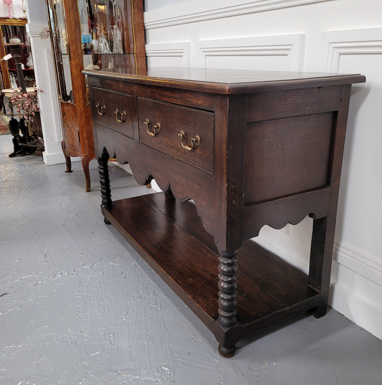 Rare size 19th Century English oak dresser base. It has two good size drawers and amazing patina. It has been sourced from France and in good original detailed condition.