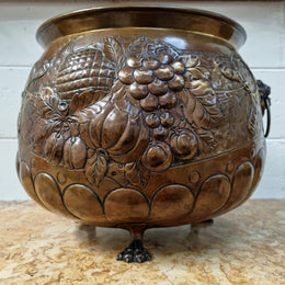 Antique large brass bronze coloured embossed Jardinière/planter with lovely details and lion heads for handles. It is in good original condition.