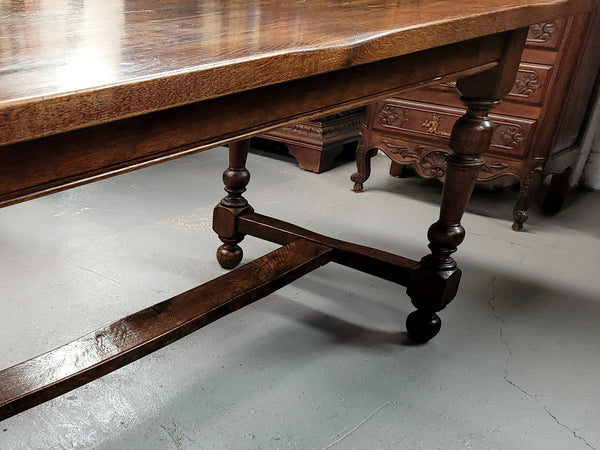 Rustic French Oak stretcher based farmhouse dining table that comfortably seats 6-8 people. It has been sourced from France and is in good original condition.