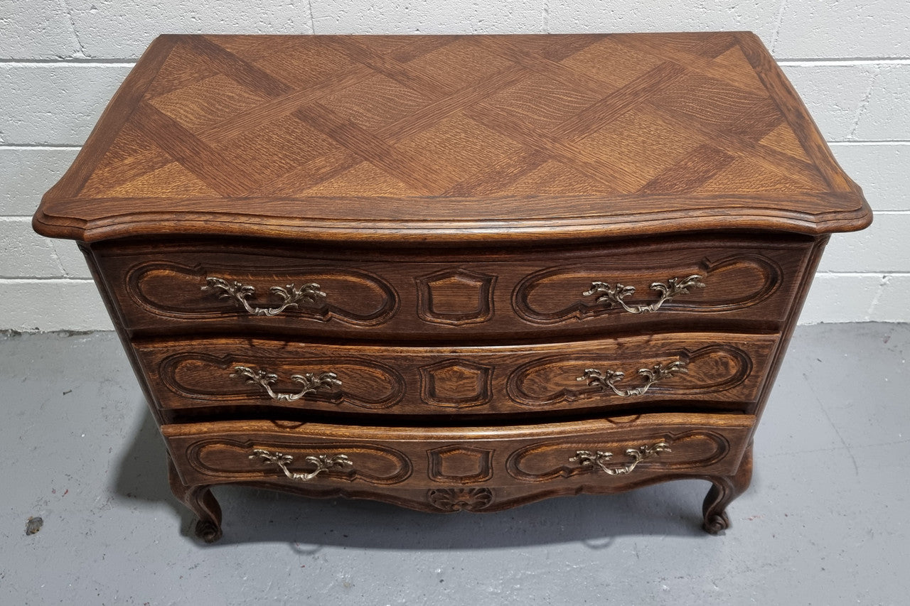 Lovely French nicely carved chest of 3 drawers with a parquetry top, with decorative handles and lovely carving. In good detailed condition.