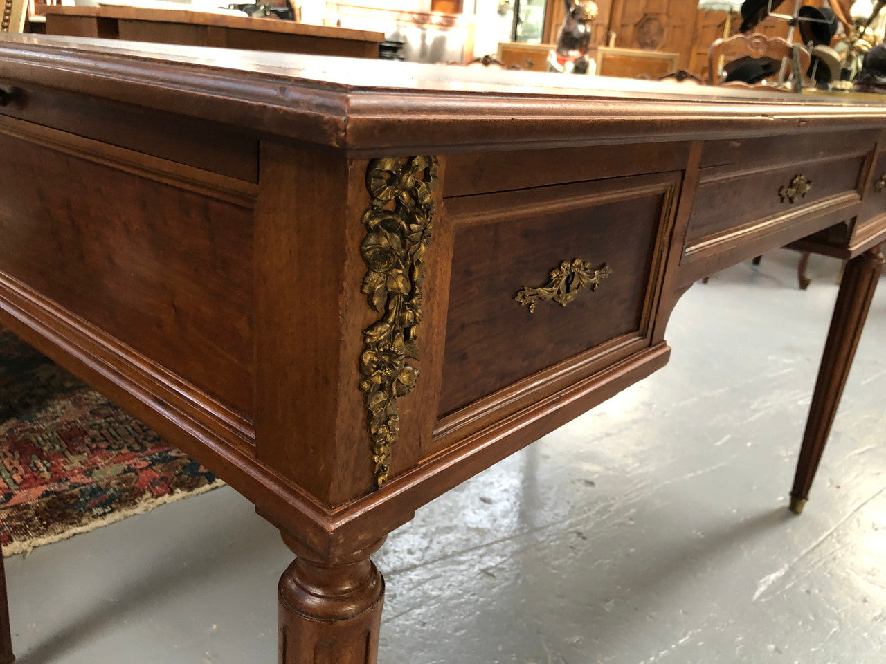 Lovely French Mahogany Louis XVI style leather top desk. With beautiful ormolu details and three drawers. There are also two slides on either side with tooled leather tops and in good original detailed condition.