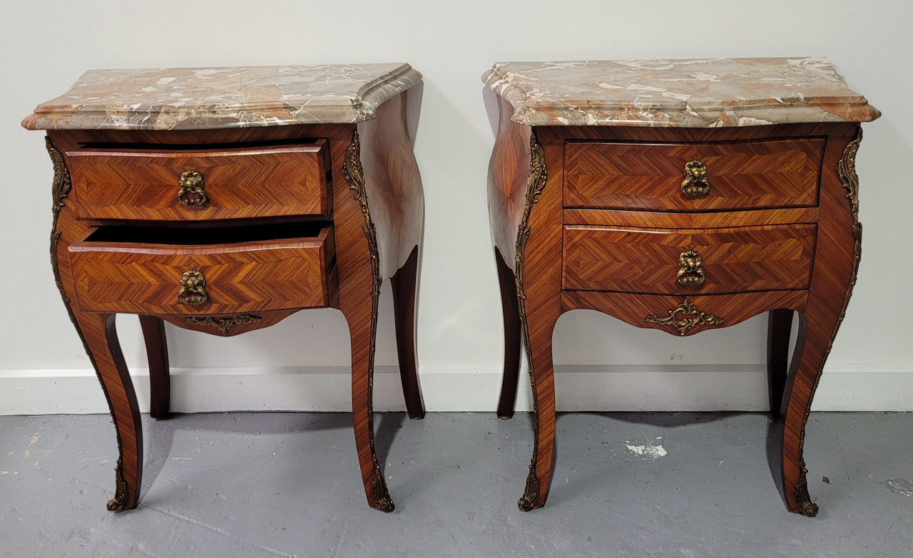 Pair of Louis XV commode style two drawer bedsides with beautiful marble tops and decorative mounts. They are a rare size and are in good, detailed condition.
