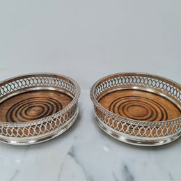 Gorgeous pair of vintage silver plate wine coasters with stunning turned wooden base. Not marked. In great original condition.