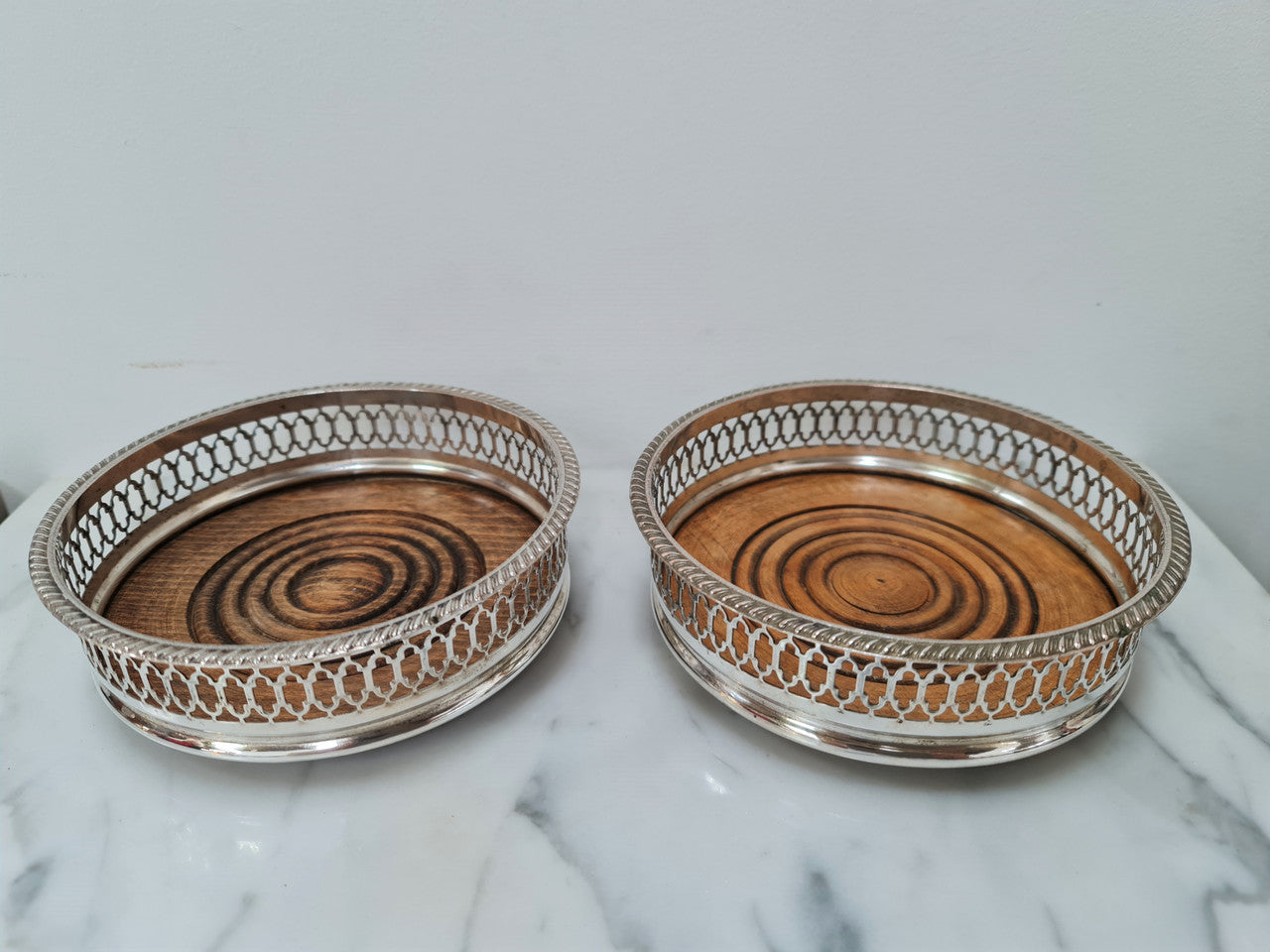 Gorgeous pair of vintage silver plate wine coasters with stunning turned wooden base. Not marked. In great original condition.