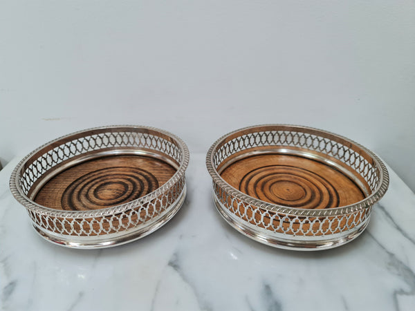 Gorgeous pair of vintage silver plate wine coasters with stunning turned wooden base. Not marked. In great original condition.