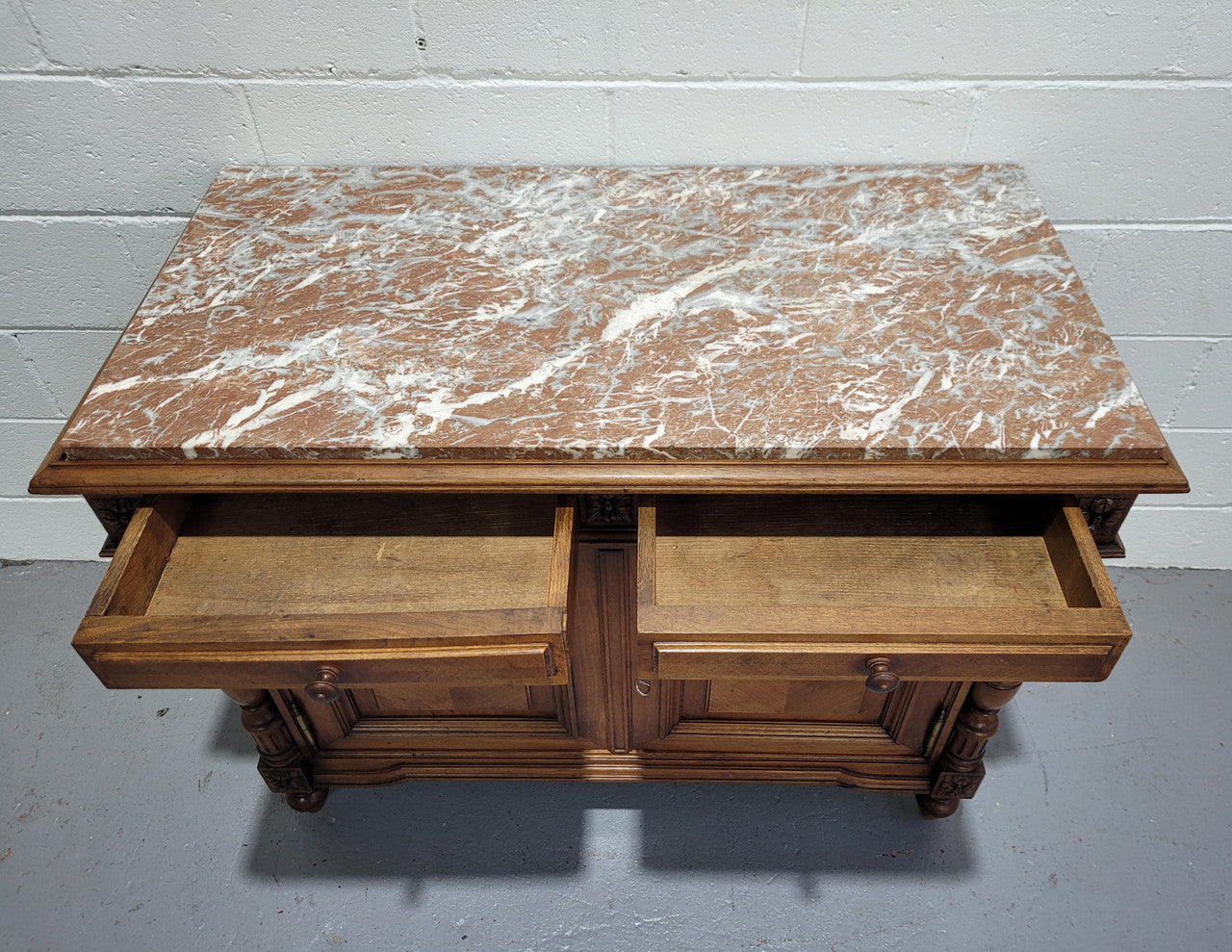 Stunning French walnut Henry II style marble top side cabinet with two drawers and two shelves inside. In good original detailed condition.