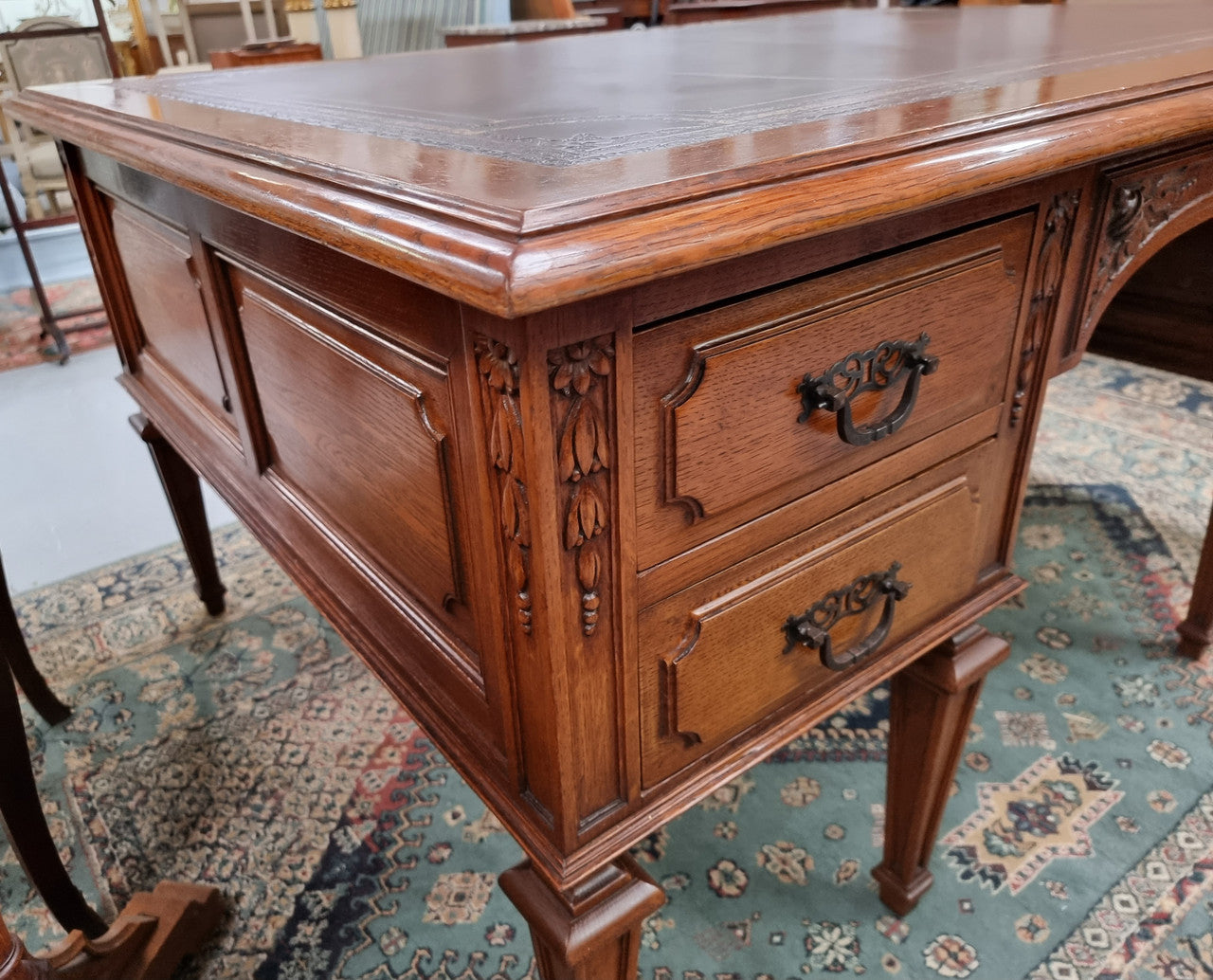 Substantial French Louis XVI style Oak partners desk. It has a beautiful leather top, two drawers on either side and decorative carvings throughout. Sourced from France and in good original detailed condition.
