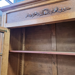 French light Oak two door bookcase with four adjustable shelves. It has beautiful decorative carving and is in good original detailed condition.