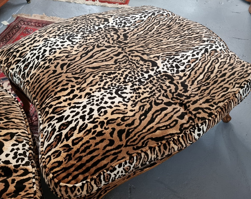 A French Louis XV style armchair with leopard print upholstery and with matched footstool. Fabric is in good original used condition. Please view photos as they help form part of the description.