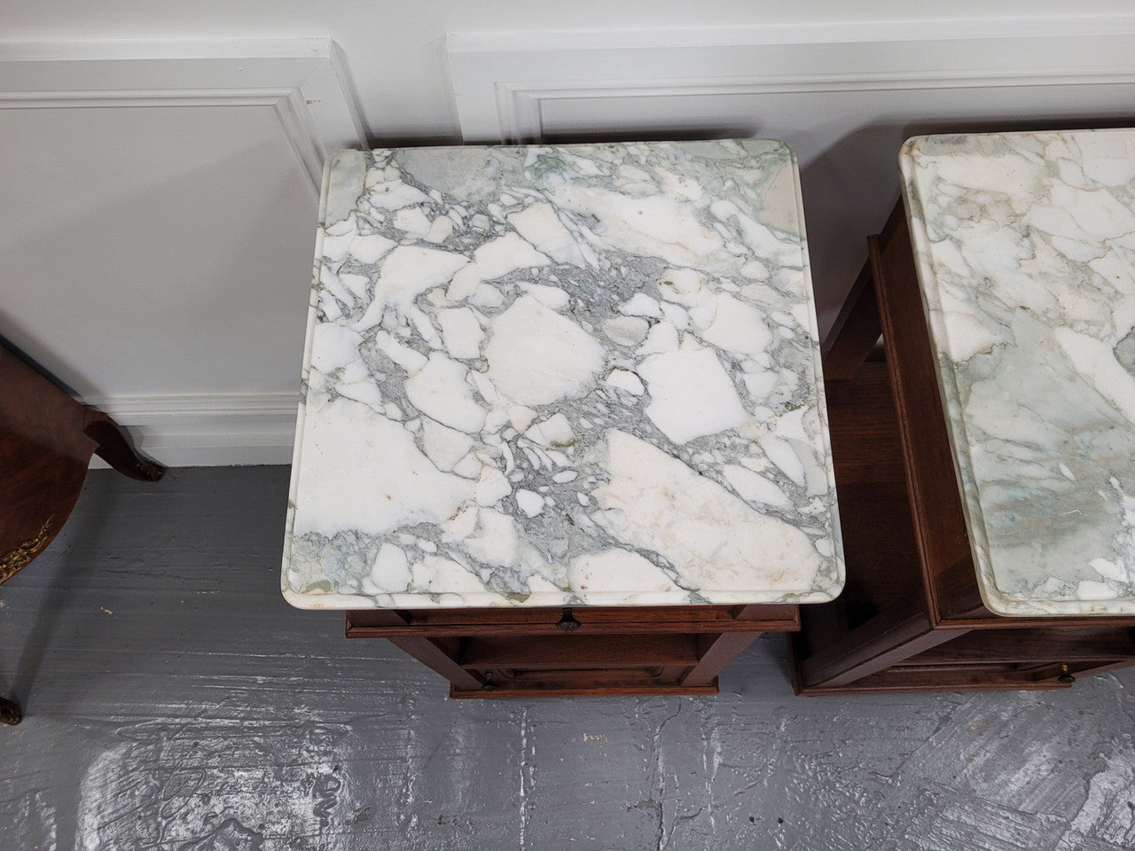 Pair of Antique French Oak Louis XVI style marble top bedside cabinets. They have decorative inlay and have been sourced from France. They are in good original detailed condition.