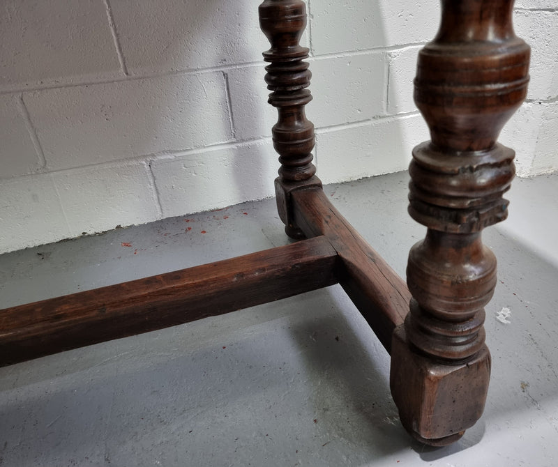 Rare and Charming 17th Century Spanish Walnut serving / side table. It has an incredible one piece walnut top with amazing character and colour. The base displays the original patina aswell as three drawers with carving and remnants of original locks. Superbly turned legs terminating on a stretcher base. Could be used as a large entrance console table, a side table or in a dining area as a serving table. In good original detailed condition especially considering its age.