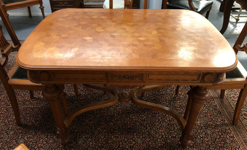 Lovely carved French Oak dining table with a parquetry top and six matching upholstered chairs in good original detailed condition.