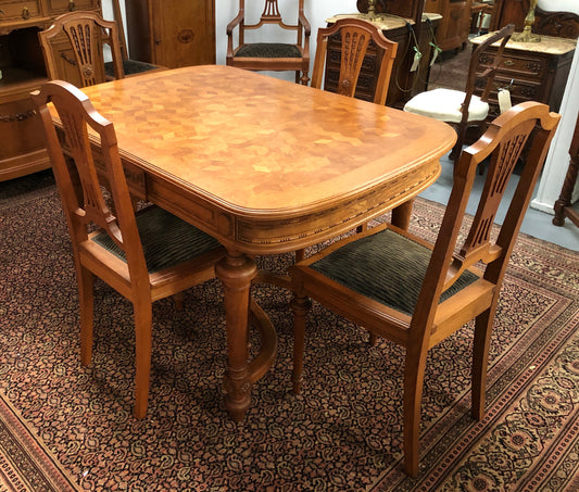 Lovely carved French Oak dining table with a parquetry top and six matching upholstered chairs in good original detailed condition.
