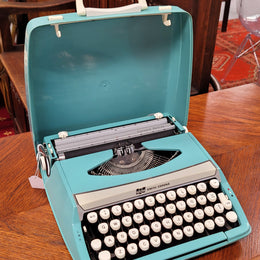 1960's Smith Corona Corsair deluxe portable typewriter. It is in working condition with a used ribbon, and comes with everything pictured. It has been sourced locally.