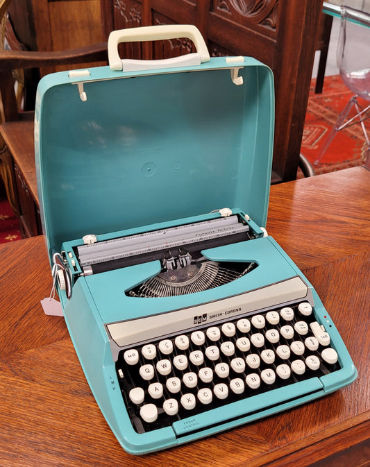 1960's Smith Corona Corsair deluxe portable typewriter. It is in working condition with a used ribbon, and comes with everything pictured. It has been sourced locally.