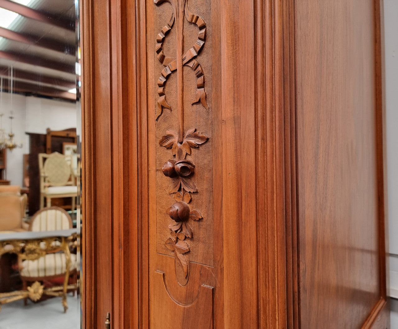 Imposing Louis XV style single mirrored door Walnut armoire. Features deep carved decoration, two interior drawers and three adjustable shelves. It is in good original detailed condition and has been sourced from France.
