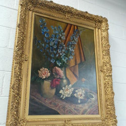 An Antique gilt-framed oil painting of floral still life. Housed in a double sweep gilt frame, signed and dated in good condition.