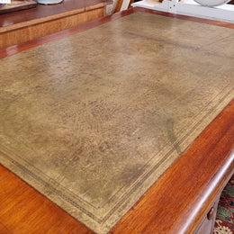 English Cedar full partners desk with attractive tooled leather top, four drawers either side and on caster wheels.  In good original detailed condition.