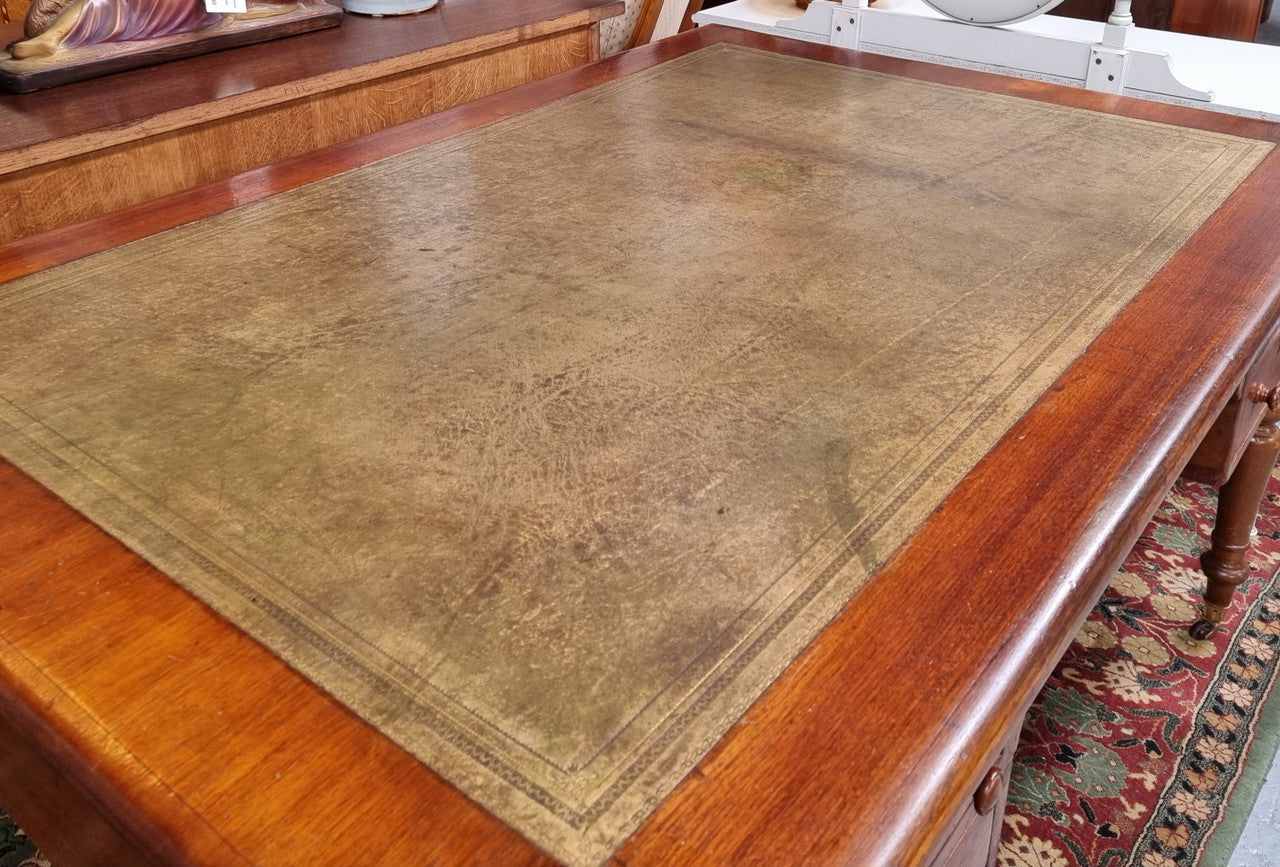 English Cedar full partners desk with attractive tooled leather top, four drawers either side and on caster wheels.  In good original detailed condition.
