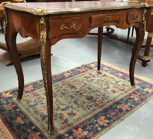 An impressive French Walnut petite Bureau Plat with superb ormolu mounts, original tooled leather top with loads of character and drawers for storage. It is in very good original detailed condition.