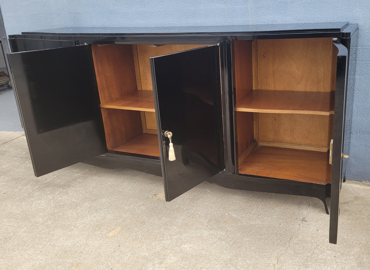 French Art Deco sideboard with a custom black lacquer finish.  Beautiful serpent shaped front with four cupboards with working locks and includes to working keys. It is in original condition.