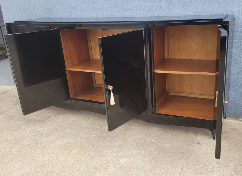 French Art Deco sideboard with a custom black lacquer finish.  Beautiful serpent shaped front with four cupboards with working locks and includes to working keys. It is in original condition.